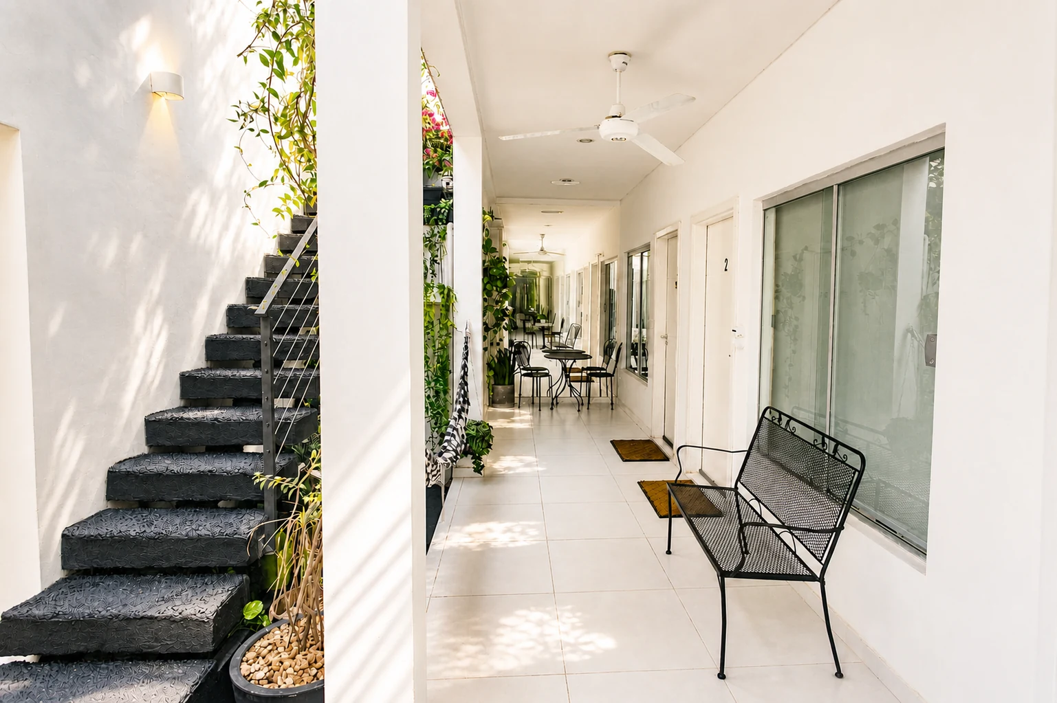 The guesthouse's shared corridor, with stairs and a bench